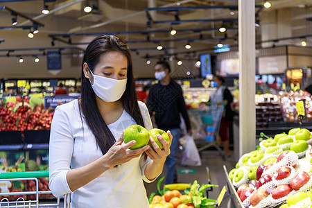 身戴保护面罩的亚洲妇女推脸和购物食物危机杂货店店铺消费者持有者大车社交中心口罩图片