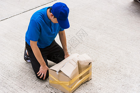 送货员 他情感快递手拿着损坏的纸箱邮递员送货商业质量船运盒子破坏纸板男人服务图片