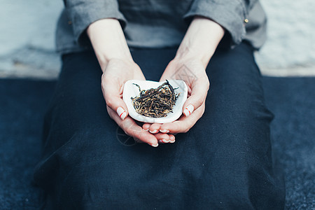 不知名的女士手里拿着一碗茶 拿给摄影机看 在电视上 她用手握着一碗茶图片