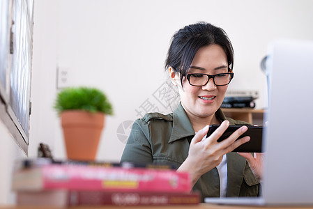 现代亚洲年轻女性玩游戏 而不是从业者内阁女孩互联网桌子电脑技术电话职场人士游戏图片