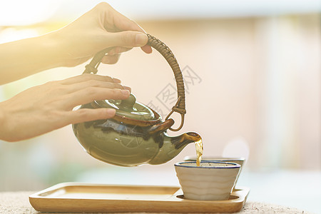 从锅到茶杯的热茶食物制品人手女士芳香花园咖啡店玻璃饮料液体图片