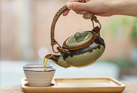 从锅到茶杯的热茶桌子人手食物花园咖啡店茶壶女士陶瓷芳香饮料图片