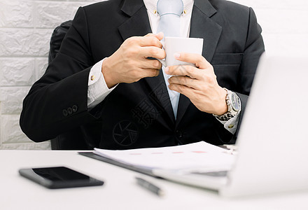 咖啡休息时 商务人士经理在办公桌上的笔记本电脑上工作主管传递同事杯子管理人员男人人士服务桌子生活图片