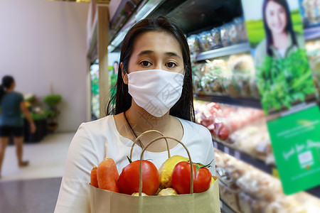 戴保护面罩的亚裔妇女持有纸购物袋顾客商店女孩持有者百货市场疾病消费者食物店铺图片