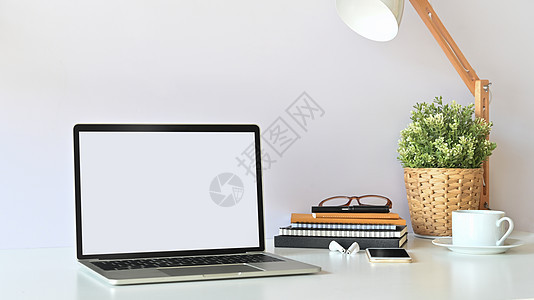 空白的笔记本电脑和办公设备放在桌面上图片