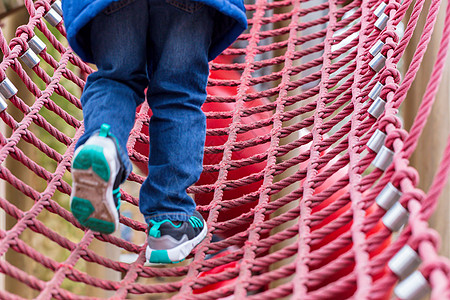 绳索攀爬框架上的小男孩低角度冒险孩子公园装备细绳网络仪器操场男生图片