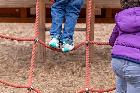 在攀爬架上玩耍的幼儿小孩子仪器梯子设备线条绳索细绳网络孩子们游乐图片