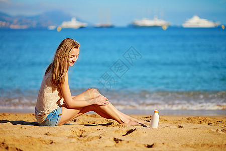 美丽的女人在腿上涂防晒霜阳光润肤旅行推杆太阳紫外线护理日光浴奶油女士图片