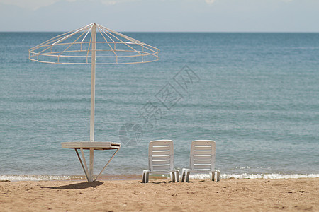 沙滩上的躺椅在岸边 放松 在海滩上放松 在海洋海中的蓝色水流动天堂椅子沉思摄影棕褐色享受阅读酒店泡沫图片