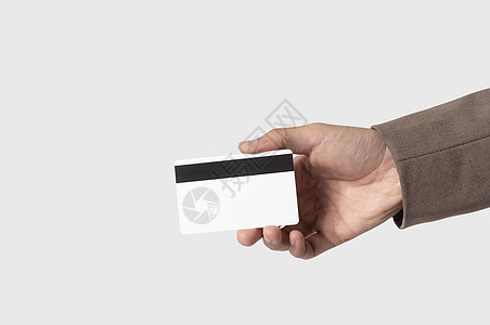 手持信用卡 以支付在灰色背景上孤立的付款借方黄色金融塑料信用财富顾客空白身份现金图片