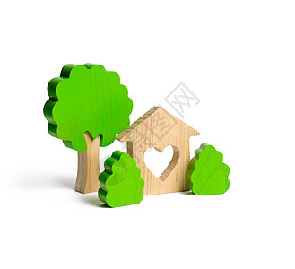 一座房子 有一颗心和木制的树木 在孤立的背景上有灌木丛 爱巢的概念 通过抵押或贷款购买经济适用房 家庭住宿图片