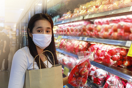 戴保护面罩的亚裔妇女持有纸购物袋女孩疾病商店消费者顾客面具购物大车食物持有者图片