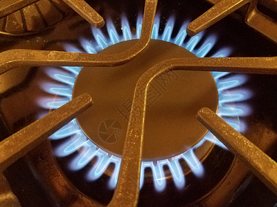 带金属格栅的天然气炉顶上的蓝色火焰烹饪气体火炉炉灶图片