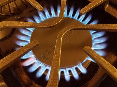 带金属格栅的天然气炉顶上的蓝色火焰炉灶气体火炉烹饪图片