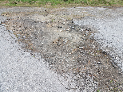 被损坏或风化或破损的黑色沥青路地面裂缝侵蚀街道损害背景图片