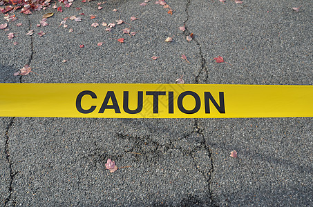 黄色警告带和沥青上的落叶裂缝警示带丝带树叶叶子胶带磁带图片