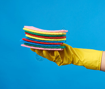 使用黄色保护性乳胶手套打扫房屋的手图片