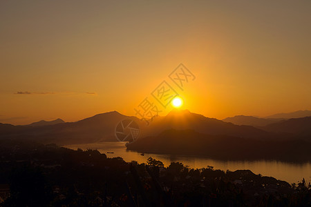 从老挝的Phou Si山看 在湄公河边阴暗的山脉上出现了光荣的夕阳天气地理太阳薄雾黑暗阴霾橙色橙子日落灯光图片