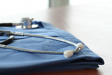 浅度D 木制桌上有蓝色医生大衣的静脉透视镜太阳速度心脏乐器检查频率心脏病学压力外套金属图片