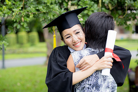 年轻女毕业生在毕业典礼上拥抱她朋友的抱抱乐趣女士家庭大学学校教育文凭幸福女性校园图片