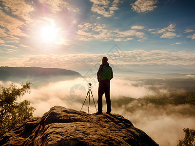 专业摄影师 悬崖上有三脚架和思索游客行动顶峰远足岩石照片本土薄雾镜子帝国图片
