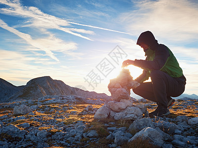 单人徒步登山者 在阿尔卑斯山的顶端 从石块中弹珠图片