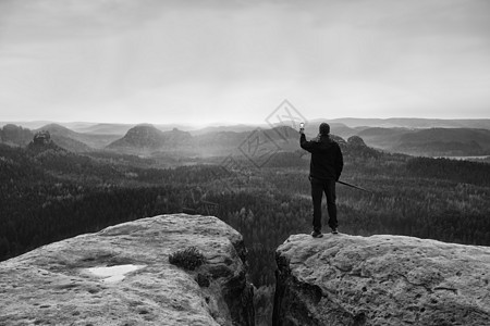 用智能手机站在山顶 享受春天的日出 导游员们向上走高度游客农村摄影师自由顶峰男人旅行地平线岩石图片