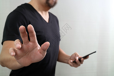 按一个假想的按钮的设计师手 拿着巧妙的电话界面渠道手势展示用户工作人士潮人男性互联网图片