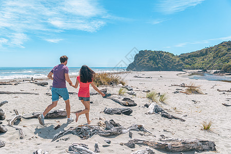 一对夫妇在新西兰的海滩上散步 手牵着手玩得很开心 — 新西兰西海岸船溪的年轻浪漫情侣 观光新西兰南岛的旅游夫妇图片
