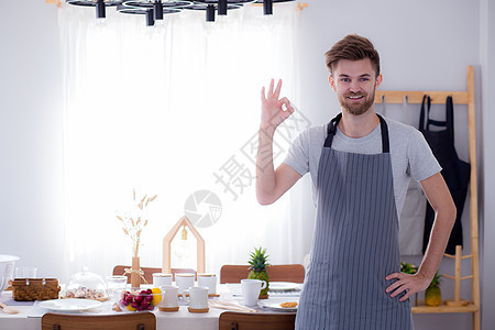 笑笑的男性烹饪 在Kitch中标出好牌背景图片