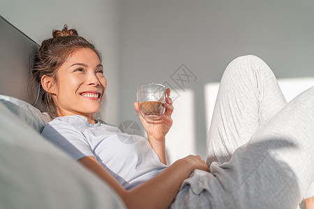 住在床上的慰安妇早上早餐喝咖啡在室内放松 亚洲女孩很高兴有空闲时间享受周末图片