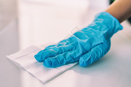 使用消毒抗菌湿巾进行表面消毒家庭清洁 以防止戴着医用蓝色手套传播 COVID-19 消毒医院和公共场所的表面预防图片