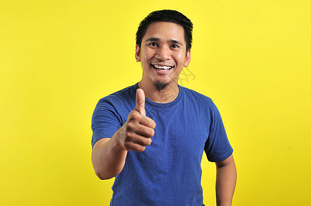 年轻亚洲男子笑的肖像 用照相机显示拇指职业学习享受青年手势成功手指协议男人成人图片