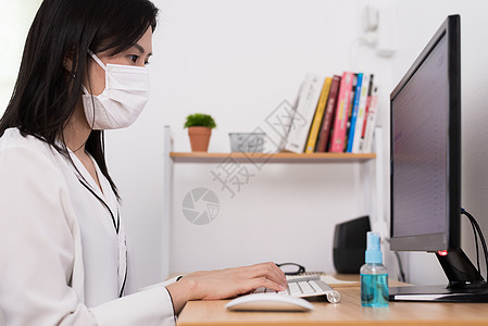 一位美丽的亚洲女商务人士 戴着面具和清洁凝胶电脑停留键盘眼镜微笑预防房间老鼠桌子蓝色图片