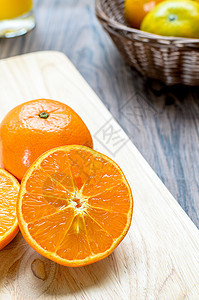 一个切橙子热带水果桌子木头木块玻璃柳条液体饮食果汁图片