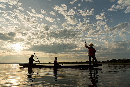 渔民在W日落时扔鱼网钓鱼的休光灯瓦农橙子男人蓝色太阳渔夫生活天空图片