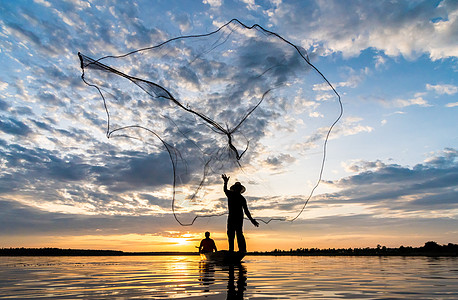 渔民在W日落时扔鱼网钓鱼的休光灯太阳男人瓦农天空渔夫生活蓝色橙子图片