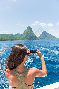 加勒比海旅行女孩在圣卢西亚皮通斯游船上用手机拍照 享受热带度假的夏季生活方式图片