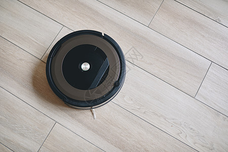 现代客厅木地板上的机器人真空吸尘器压板家政沙发家庭木头房间机器地面黑色房子图片