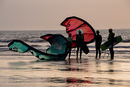 Kite冲浪者在日落时从海中回来海洋自由运动天空海滩假期冲浪旅行海浪风筝图片