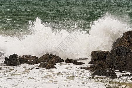 夏季暴风雨期间 愤怒的海浪在海岸岩石上碰撞休息室海岸线泡沫风暴支撑太阳天空海景海滨蓝色图片