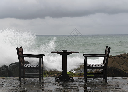 在弃置桌旁海岸岩石上坠毁的纳里海浪旅行海岸线海景座位太阳碰撞休息室假期海洋椅子图片