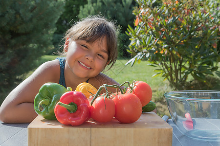 棕色的微笑着的小女孩的肖像 里面有新鲜蔬菜图片