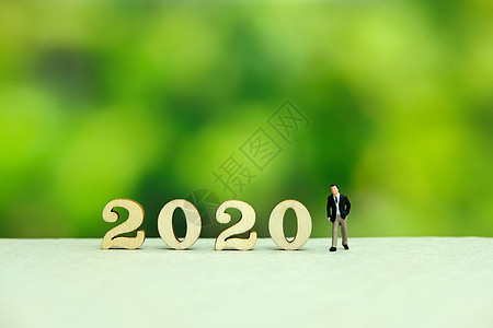 商务人士用梦幻般的绿色背景迎接 2020 年新年快乐问候语工人商务庆典摄影战略人士假期数字桌子图片