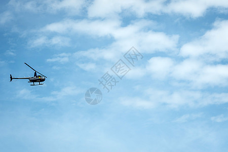 直升机在浅蓝的天空背景下 以休眠速度飞行员乘客危险航空车辆刀刃菜刀螺旋桨空气图片