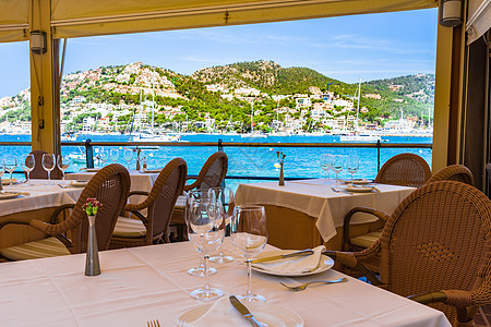 餐厅的餐桌设置 以海景显示美丽的海岸湾和游艇图片