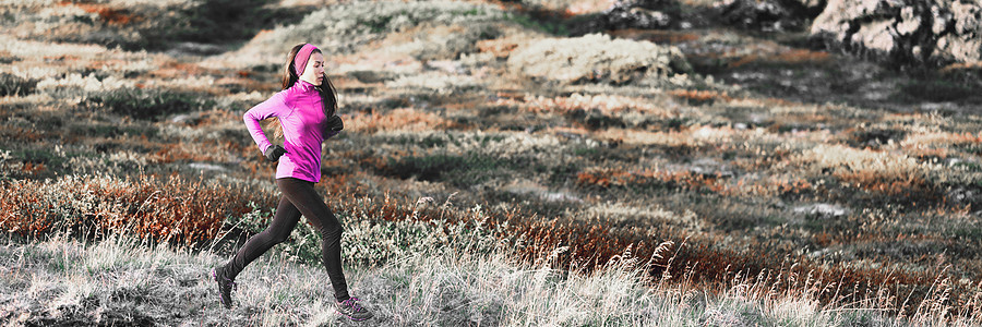 在冬季足迹山横幅背景中跑步的女人 跑步运动员在寒冷的户外训练有氧运动 穿着保暖紧身裤和粉红色衣服的亚洲女孩图片