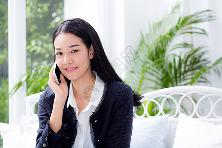 坐在沙发上聊天时在家打电话的女人的肖像人士讲话微笑办公室电话女士商务女孩工作女性图片