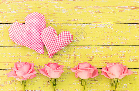 两颗粉红红心 黄色背景上有美丽的玫瑰图片