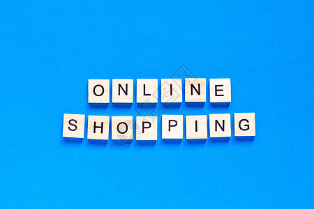 蓝色背景上用木制字母写的在线购物题词 在线购买交付业务的概念图片